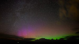 Aurora borealis lights up the starry night sky.